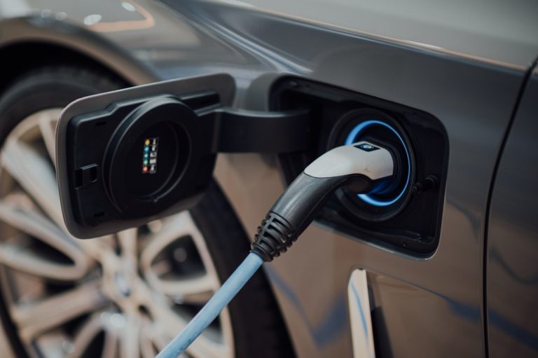 Electrician installing EV charger at fleet depot