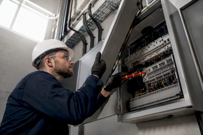 Electrician testing wiring in commercial panel