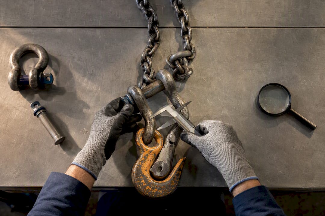Engineer checking chain sling and shackle